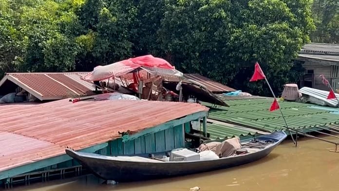 Flooding forces Thai man to live on his roof for weeks